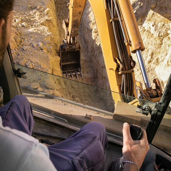 Inside excavator digging trench | Wellons Land & Development